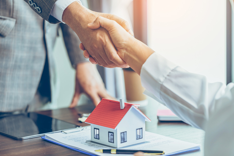 A real estate agent and a client shake hands, symbolizing a successful partnership in Ogden's Lighthouse Home Selling Solution.