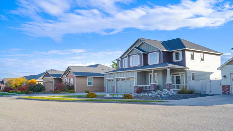 A row of houses featuring driveways and garages, showcasing Taylorsville's lighthouse home selling solution.