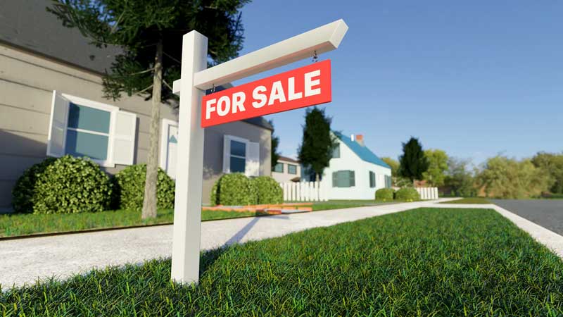 A for sale sign stands prominently in front of a house in Taylorsville, showcasing the lighthouse home selling solution.